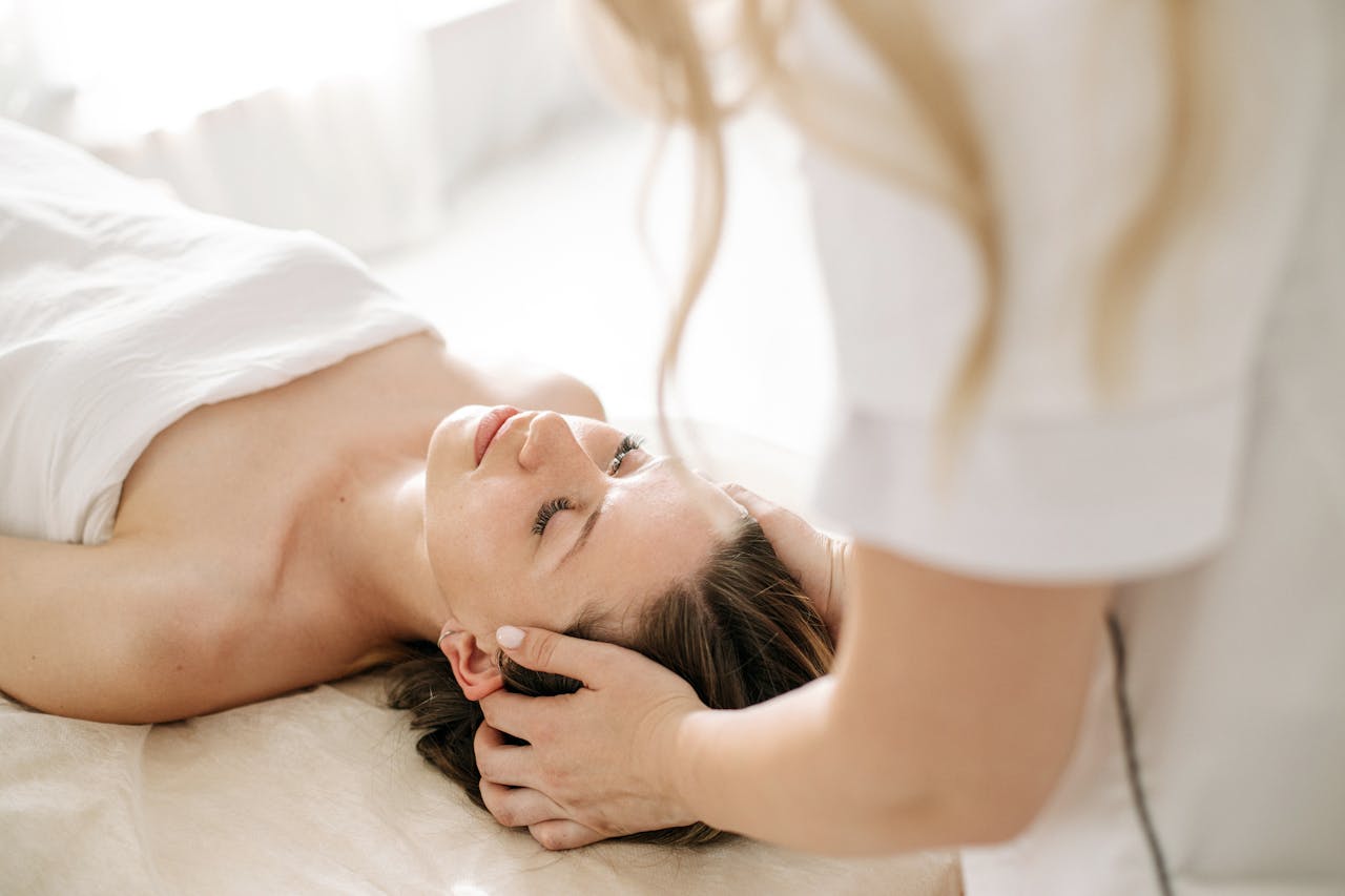 programs-02 A woman receiving a calming head massage at a spa, promoting relaxation and wellness.