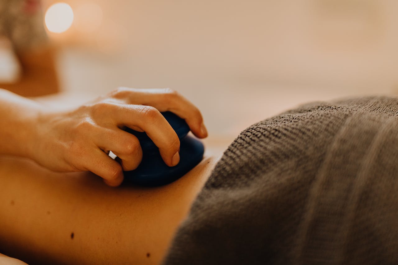 our-facilities-02 Hands applying relaxing massage therapy with hot stones in a calming spa environment.