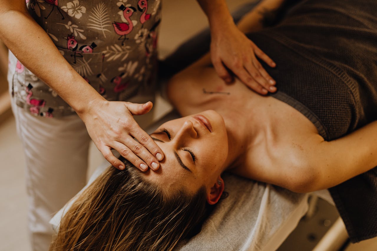 about-img A tranquil scene of a woman receiving a therapeutic head massage at a spa.